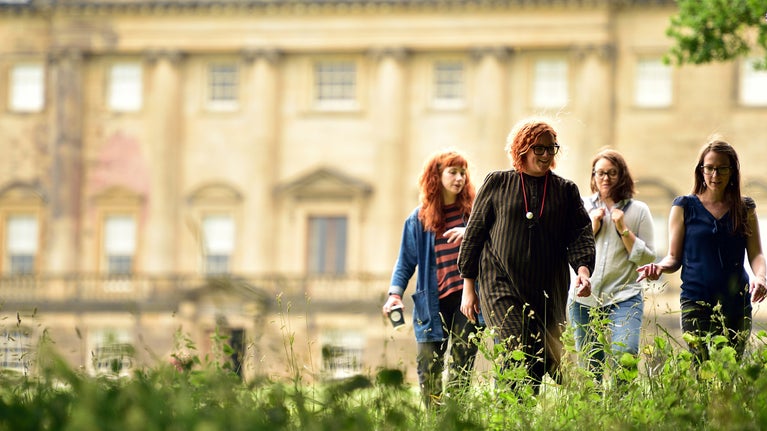A group walk in front of the 18th Century mansion house at Nostell